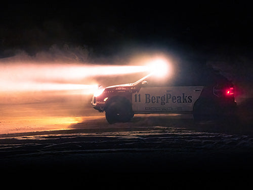 LED light bars and pods mounted on Porsche Cayenne, lit up during night trail run with full off-road gear