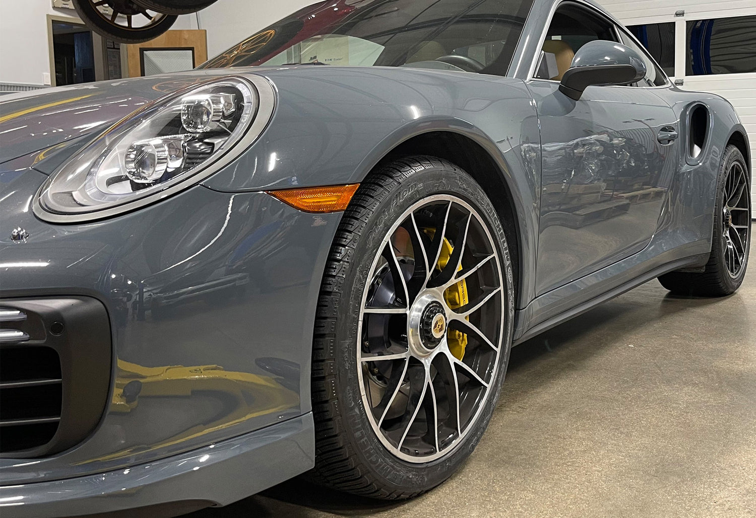 Lifted Porsche 911 991 with safari wheels and roof-mounted lighting kicking up dirt on a gravel trail